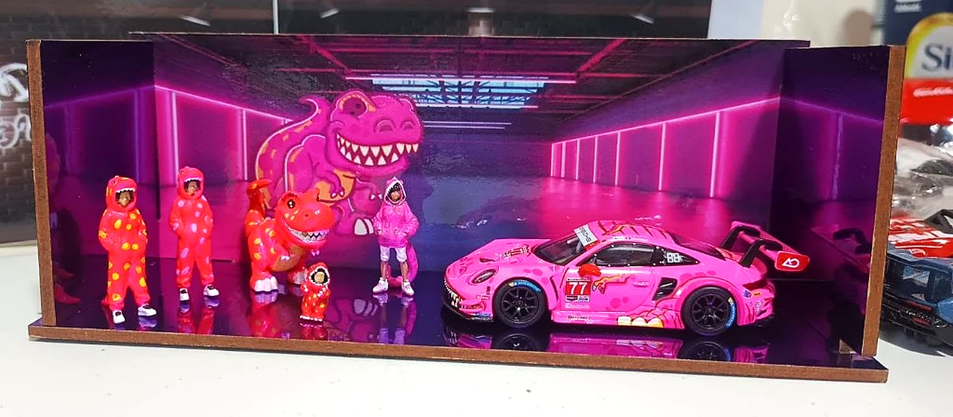 Diorama personalizado con Porsche rosa y figuras de dinosaurios — Bogotá